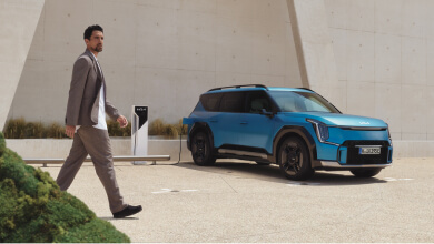 Plug & Charge, Mann läuft vor EV9 an Ladesäule vorbei