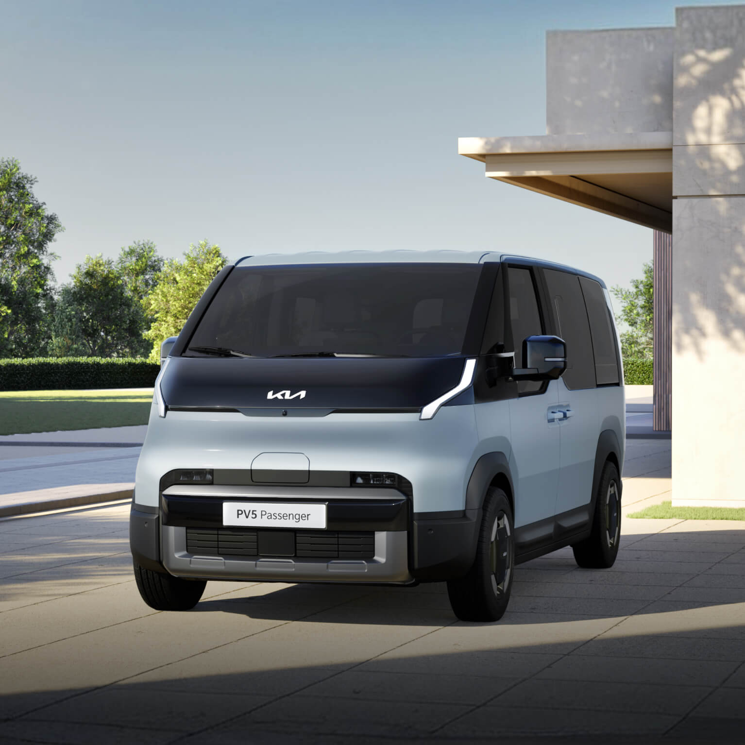 Vue avant du Kia PV5 Passenger garé dans un quartier résidentiel moderne, mettant en valeur son design extérieur épuré et géométrique.