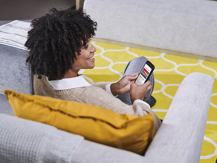 Woman is sitting on the couch and using a Kia service app